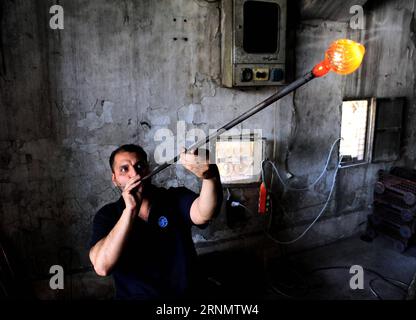 (170611) -- DAMASKUS, 11. Juni 2017 -- Ein syrischer Glasbläser formt geschmolzenes Glas in seiner Werkstatt in Damaskus, der Hauptstadt Syriens, am 11. Juni 2017. Mit einer Technik, die vor etwa 2.000 Jahren von den Phöniziern entwickelt wurde, formten die Glasbläser das geschmolzene Glas in einem Ofen, um traditionelle Glaswaren herzustellen, die in Damaskus beliebt sind. ) SYRIEN-DAMASKUS-TRADITIONELLE GLASHERSTELLUNG AmmarxSafarjalani PUBLICATIONxNOTxINxCHN 170611 Damaskus 11. Juni 2017 ein syrischer Glasbläser formt geschmolzenes Glas AUF seiner Werkstatt in Damaskus Hauptstadt Syrien AM 11. Juni 2017 mit einer Technik, die zuerst von Phöniziern etwa 2 000 Jäa entwickelt wurde Stockfoto