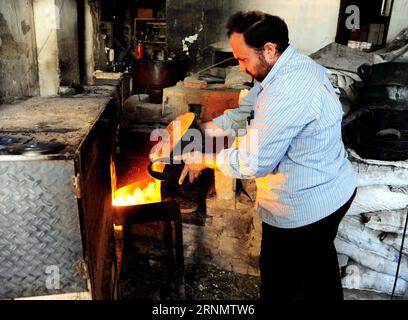 (170611) -- DAMASKUS, 11. Juni 2017 -- Ein syrischer Glasbläser stellt am 11. Juni 2017 in seiner Werkstatt in Damaskus, der Hauptstadt Syriens, geschmolzenes Glas in einen Ofen. Mit einer Technik, die vor etwa 2.000 Jahren von den Phöniziern entwickelt wurde, formten die Glasbläser das geschmolzene Glas in einem Ofen, um traditionelle Glaswaren herzustellen, die in Damaskus beliebt sind. ) SYRIEN-DAMASKUS-TRADITIONELLE GLASHERSTELLUNG AmmarxSafarjalani PUBLICATIONxNOTxINxCHN 170611 Damaskus 11. Juni 2017 ein syrischer Glasbläser stellt geschmolzenes Glas in seiner Werkstatt in der syrischen Hauptstadt Damaskus AM 11. Juni 2017 unter Verwendung einer von Phoenici entwickelten Technik in den OFEN Stockfoto