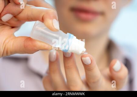 Das Mädchen benutzt eine Flasche medizinischer Tropfen Stockfoto