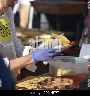 San Sebastian, Spanien - 21. Dezember 2022: Baskische Bauern rösten Txistorra (frischer Chorizo), das typische Streetfood am Tag des Heiligen Thomas Stockfoto