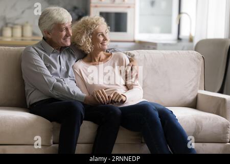 Glückliches reifes, pensioniertes Ehepaar, das zusammen auf dem Sofa ruht Stockfoto