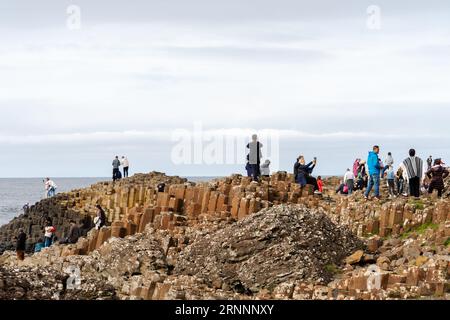 Riesen's Causeway, in der Nähe von Bushmills, Nordirland. Besucher der natürlichen Basalt-Felsformationen, die eine beliebte Touristenattraktion sind. Stockfoto