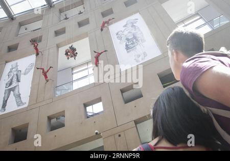 (170724) -- VANCOUVER, 24. Juli 2017 -- Menschen beobachten Tänzerinnen auf der Außenwand der Vancouver Public Library in Vancouver, Kanada, 23. Juli 2017. Die in Vancouver ansässige Aeriosa Dance Company führte am Sonntag Tanz in der Luft an der Außenwand der Vancouver Public Library auf. Tänzerinnen wurden in der Luft aus dem fünften Stock gehängt und mit einem Thema über die Geschichte von Kanadas indigenen Völkern aufgeführt. ) (zy) CANADA-VANCOUVER-DANCE IN THE AIR LiangxSen PUBLICATIONxNOTxINxCHN Vancouver 24. Juli 2017 Prominente Beobachten Sie Tänzerinnen AUF der Außenwand der Vancouver Public Library in Vancou Stockfoto