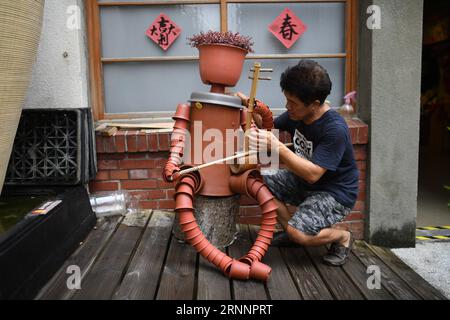 (170725) -- YUNLIN, 25. Juli 2017 -- der Installationskünstler Chen Weiguang setzt eine Blumentopf-Puppe, die Erhu, ein chinesisches Musikinstrument, spielt, im Yunlin County im Südosten Chinas, Taiwan, 24. Juli 2017. Chen begann vor zehn Jahren, alte Blumentöpfe wiederzuverwenden, um Marionetten herzustellen, und jetzt hat er über 1.000 Marionetten geschaffen. ) (zx) CHINA-TAIWAN-FLOWERPOT PUPPETS (CN) ZhouxMi PUBLICATIONxNOTxINxCHN Yunlin Juli 25 2017 Installationskünstlerin Chen Weiguang setzt eine Blumentopf-PUPPE, die Erhu spielt ein chinesisches Musikinstrument IM Yunlin County in Südostchina. 24. Juli 2017 begann Chen, alten Blumentopf wiederzuverwenden Stockfoto