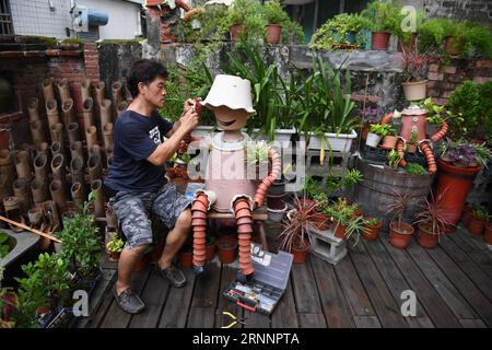 (170725) -- YUNLIN, 25. Juli 2017 -- die Installationskünstlerin Chen Weiguang inszeniert am 24. Juli 2017 eine Blumentopf-Puppe im Yunlin County im südchinesischen Taiwan. Chen begann vor zehn Jahren, alte Blumentöpfe wiederzuverwenden, um Marionetten herzustellen, und jetzt hat er über 1.000 Marionetten geschaffen. ) (zx) CHINA-TAIWAN-FLOWERPOT PUPPETS (CN) ZhouxMi PUBLICATIONxNOTxINxCHN Yunlin Juli 25 2017 Installationskünstler Chen Weiguang stellt eine Blumentopf-PUPPE IM Yunlin County in Südostchina ein. 24. Juli 2017 begann Chen, alte Blumentöpfe wiederzuverwenden, um Marionetten herzustellen, und jetzt hat er über 1 000 geschaffen Puppen ZX China TAI Stockfoto