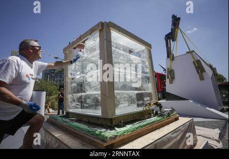 (170728) -- VANCOUVER, 28. Juli 2017 -- Arbeiter stapeln Eisblöcke während der Ice Box Challenge in Vancouver, Kanada, 27. Juli 2017. Die Ice Box Challenge ist ein öffentliches Experiment, um die Vorteile von superenergieeffizienten Gebäuden unter dem Passivhausbaustandard zu demonstrieren. Zwei kleine, hausähnliche Boxen, die mit Passivhausstandard und örtlichen Bauvorschriften gebaut wurden, sitzen 18 Tage lang nebeneinander unter freiem Raum und haben einen 1-Tonnen-Eisblock ummantelt, um den neuen emissionsfreien Gebäudestandard zu belegen.) KANADA-VANCOUVER-ICE BOX CHALLENGE Liangxsen PUBLICATIONxNOTx Stockfoto