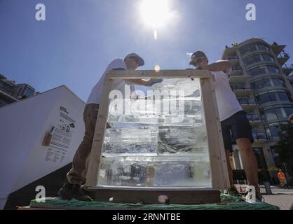 (170728) -- VANCOUVER, 28. Juli 2017 -- Arbeiter stapeln Eisblöcke während der Ice Box Challenge in Vancouver, Kanada, 27. Juli 2017. Die Ice Box Challenge ist ein öffentliches Experiment, um die Vorteile von superenergieeffizienten Gebäuden unter dem Passivhausbaustandard zu demonstrieren. Zwei kleine, hausähnliche Boxen, die mit Passivhausstandard und örtlichen Bauvorschriften gebaut wurden, sitzen 18 Tage lang nebeneinander unter freiem Raum und haben einen 1-Tonnen-Eisblock ummantelt, um den neuen emissionsfreien Gebäudestandard zu belegen.) KANADA-VANCOUVER-ICE BOX CHALLENGE Liangxsen PUBLICATIONxNOTx Stockfoto