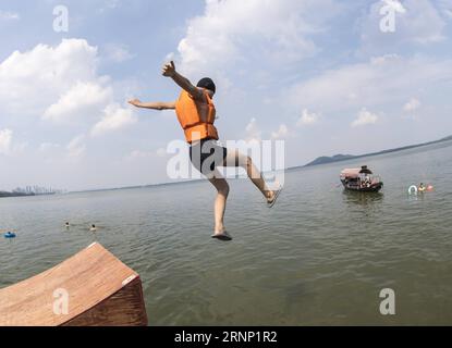 (170806) -- WUHAN, 6. August 2017 -- Ein Mann springt in den Donghu-See von einer Plankstraße der Wuhan-Universität in Wuhan, zentralchinesische Provinz Hubei, 6. August 2017. Die Menschen finden verschiedene Möglichkeiten, in Wuhan ins Wasser zu springen, um sich bei heißem Wetter abzukühlen. ) (Xzy) CHINA-WUHAN-DONGHU-SEE-SPRUNG (CN) XiongxQi PUBLICATIONxNOTxINxCHN Wuhan 6. August 2017 ein Mann springt von einer Plankstraße der Wuhan Universität in Wuhan Zentralchina S Hubei Provinz 6. August 2017 Berühmtheiten finden verschiedene Wege, um sich bei heißem Wetter in Wuhan abzukühlen China Wuhan Donghu Lake Jump CN XiongxQi PUB Stockfoto