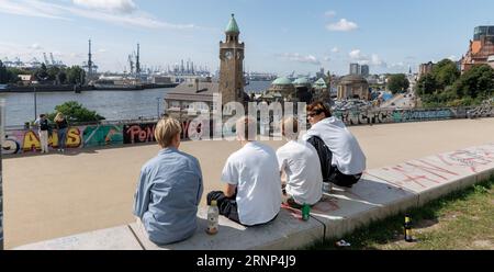 Hamburg, Deutschland. September 2023. Vier junge Männer genießen einen sonnigen Tag am Stintfang mit Blick auf die Elbe, die Landestege und den Hafen. Quelle: Markus Scholz/dpa/Alamy Live News Stockfoto
