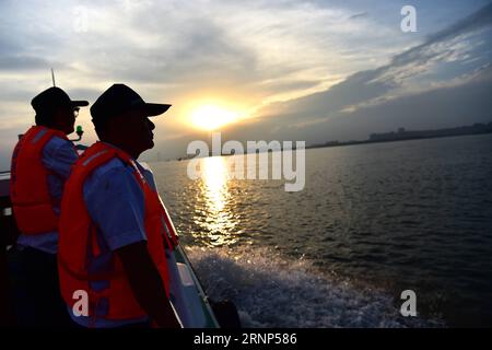 (170811) -- ANQING, 11. Aug. 2017 -- Hilfspatrouillen arbeiten auf einem Boot im fussellosen Schweinswal-Naturschutzgebiet in Anqing der ostchinesischen Provinz Anhui, 10. Aug. 2017. Eine Hilfspatrouillenbrigade, darunter 6 ehemalige Fischer, begann ihre Mission im Juni 2017, um die 60 fussellosen Schweinswale entlang des 60 Kilometer langen Abschnitts des Jangtse River in der Provinz zu schützen. Bei ihren routinemäßigen Missionen wird die telefonische Anwendung verwendet, um das Leben des Delfinsäugers zu verfolgen und zu beobachten, den erforderlichen Schutz zu bieten und die Schadstoffe und die illegale Fischerei im Reservat zu überwachen. ) (CLQ) CHINA-ANHUI-ANQING-ECOLOG Stockfoto