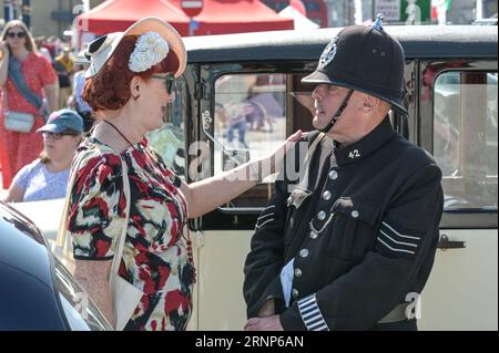 Morecambe, Lancashire - 2. September 2023 - Besucher genossen Morecambes Vintage by the Sea Festival am Samstag. Viele von ihnen kamen in Vintage-Kleidung und ließen die Atmosphäre aufsaugen. Ein Mann erholte sich im Schatten seines Oldtimers und las eine Zeitung, als die Sonne unterging. Quelle: Stop Press Media/Alamy Live News Stockfoto