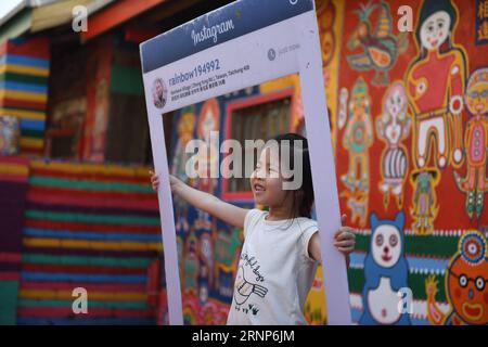 (170813) -- TAICHUNG, 13. August 2017 -- Ein Mädchen besucht eine Wohngemeinde namens Rainbow Village im Nantun-Bezirk der Stadt Taichung im Südosten Chinas Taiwan, 12. August 2017. Huang Yong-Fu, ein 95-jähriger Veteran, malte vor einigen Jahren farbenfrohe Tiere und Figuren auf die Wände und das Gelände des Dorfes. Seine Gemälde zogen viele Touristen an und retteten auch das sterbende Dorf vor der Entfernung. Er steht jeden Tag um 3 Uhr morgens auf, um die Gemälde seines Dorfes zu reparieren. ) (Zkr)(zt) CHINA-TAICHUNG- RAINBOW VILLAGE (CN) ZhouxMi PUBLICATIONxNOTxINxCHN Taichung 13. August 2017 ein Mädchen besucht A Stockfoto