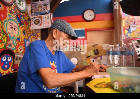 (170813) -- TAICHUNG, 13. August 2017 -- Huang Yong-Fu unterzeichnet Autogramme für Touristen in einer Wohnsiedlung namens Rainbow Village im Nantun Bezirk der Stadt Taichung, Südostchina Taiwan, 12. August 2017. Huang Yong-Fu, ein 95-jähriger Veteran, malte vor einigen Jahren farbenfrohe Tiere und Figuren auf die Wände und das Gelände des Dorfes. Seine Gemälde zogen viele Touristen an und retteten auch das sterbende Dorf vor der Entfernung. Er steht jeden Tag um 3 Uhr morgens auf, um die Gemälde seines Dorfes zu reparieren. ) (Zkr)(zt) CHINA-TAICHUNG-RAINBOW VILLAGE (CN) ZhouxMi PUBLICATIONxNOTxINxCHN Tai Stockfoto