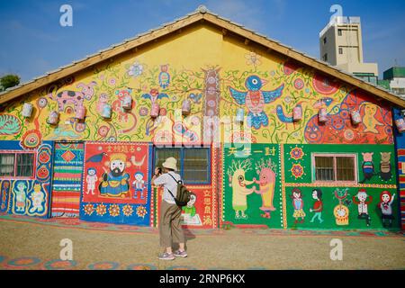 (170813) -- TAICHUNG, 13. August 2017 -- Touristen besuchen eine Wohnsiedlung namens Rainbow Village im Nantun-Bezirk der Stadt Taichung, Südostchinas Taiwan, 12. August 2017. Huang Yong-Fu, ein 95-jähriger Veteran, malte vor einigen Jahren farbenfrohe Tiere und Figuren auf die Wände und das Gelände des Dorfes. Seine Gemälde zogen viele Touristen an und retteten auch das sterbende Dorf vor der Entfernung. Er steht jeden Tag um 3 Uhr morgens auf, um die Gemälde seines Dorfes zu reparieren. ) (Zkr)(zt) CHINA-TAICHUNG- RAINBOW VILLAGE (CN) ZhouxMi PUBLICATIONxNOTxINxCHN Taichung 13. August 2017 Touristen besuchen Stockfoto