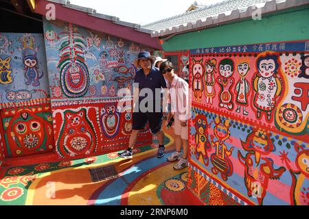 (170813) -- TAICHUNG, 13. August 2017 -- Touristen besuchen eine Wohnsiedlung namens Rainbow Village im Nantun-Bezirk der Stadt Taichung, Südostchinas Taiwan, 12. August 2017. Huang Yong-Fu, ein 95-jähriger Veteran, malte vor einigen Jahren farbenfrohe Tiere und Figuren auf die Wände und das Gelände des Dorfes. Seine Gemälde zogen viele Touristen an und retteten auch das sterbende Dorf vor der Entfernung. Er steht jeden Tag um 3 Uhr morgens auf, um die Gemälde seines Dorfes zu reparieren. ) (Zkr)(zt) CHINA-TAICHUNG- RAINBOW VILLAGE (CN) ZhouxMi PUBLICATIONxNOTxINxCHN Taichung 13. August 2017 Touristen besuchen Stockfoto