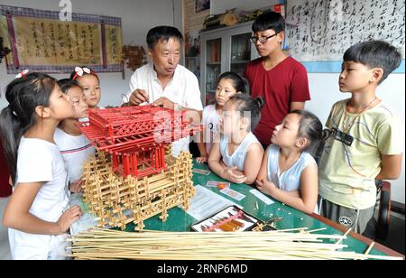 (170813) -- CANGZHOU, 13. August 2017 -- Wei Qingfa, 60, ein Strohwebkünstler, erklärt den Schülern, wie man im Dorf Gaoguantun im Cangxian County, Provinz Hebei, im Norden Chinas, am 13. August 2017 webt. Wei bietet während der Sommerferien kostenlose Kurse zum Thema Strohweberei an. Li Peng) (clq) CHINA-HEBEI-CANGZHOU-SUMMER VACATION(CN) MouxYu PUBLICATIONxNOTxINxCHN Cangzhou Aug 13 2017 Wei 60 ein Strohwebkünstler erklärt den Studenten, wie man im Dorf Cangxian County Nordchina S Hebei Provinz 13. Aug 2017 Wei BIETET kostenlose Kurse AUF Strohwebmaschinen für das St. Weberei Handwerk Stockfoto