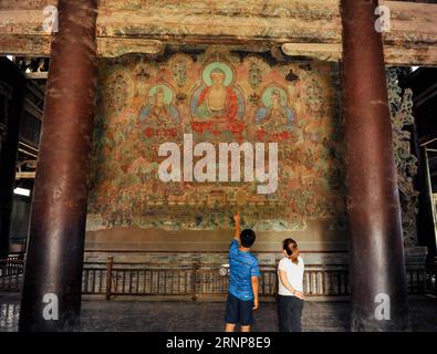 (170816) -- ZHENGDING, 16. August 2017 -- Ein Mitarbeiter stellt einem Besucher im Longxing-Tempel in Zhengding, nordchinesische Provinz Hebei, am 15. August 2017 Ein altes Wandgemälde vor. Die Restaurierungs- und Restaurierungsarbeiten der buddhistischen Wandmalereien der Ming-Dynastie (1368-1644) auf 400 Quadratmetern sind im Gange. (zx) CHINA-HEBEI-LONGXING TEMPLE-MURALS (CN) ChenxQibao PUBLICATIONxNOTxINxCHN 170816 Zhengding 16. August 2017 ein Mitarbeiter stellt einem Besucher DES Longxing-Tempels in Zhengding, Nordchina, Provinz Hebei, 2017 die Restaurierungs- und Konservierungsarbeiten vor Stockfoto