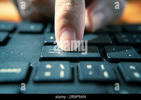 Drücken der ENTER-Taste auf einer Computertastatur Stockfoto