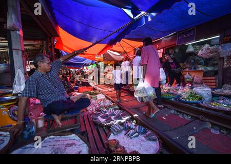 (170821) -- MAEKLONG, 21. August 2017 -- Kunden besuchen Maeklong Market in der zentralthailändischen Provinz Samut Songkhram, 19. August 2017. Im Maeklong Market, der entlang einer Eisenbahnstrecke gebaut wurde, wird ein Kompromiss zwischen Anbietern und vorbeifahrenden Pendlerzügen erzielt. Wenn die Gleise frei sind, können Standbesitzer nach Belieben Stände einrichten; doch acht Mal am Tag müssen die Markisen und ein Teil der Güter von der Bahn zurückgebracht werden, um Platz für ein- und ausfahrende Züge zu schaffen. Der Geschäftsstil rund um die Zugfahrpläne hat Maeklong Market zu einem der einzigartigsten Märkte in Thailand gemacht. ) (dtf) THAILAND-MAEKLO Stockfoto