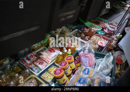 (170821) -- MAEKLONG, 21. Aug. 2017 -- Ein Pendelzug fährt täglich Waren, die an einem Stand auf dem Maeklong Market in der zentralthailändischen Provinz Samut Songkhram, 20. Aug. 2017, verkauft werden. Im Maeklong Market, der entlang einer Eisenbahnstrecke gebaut wurde, wird ein Kompromiss zwischen Anbietern und vorbeifahrenden Pendlerzügen erzielt. Wenn die Gleise frei sind, können Standbesitzer nach Belieben Stände einrichten; doch acht Mal am Tag müssen die Markisen und ein Teil der Güter von der Bahn zurückgebracht werden, um Platz für ein- und ausfahrende Züge zu schaffen. Der Geschäftsstil rund um die Zugfahrpläne hat Maeklong Market zu einem der einzigartigsten gemacht Stockfoto