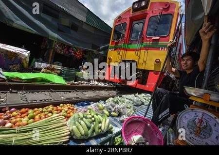 Bilder des Tages (170821) -- MAEKLONG, 21. Aug. 2017 -- Ein Pendelzug fährt durch den Maeklong Market in der Samut Songkhram Provinz in Zentralthailand, 19. Aug. 2017. Im Maeklong Market, der entlang einer Eisenbahnstrecke gebaut wurde, wird ein Kompromiss zwischen Anbietern und vorbeifahrenden Pendlerzügen erzielt. Wenn die Gleise frei sind, können Standbesitzer nach Belieben Stände einrichten; doch acht Mal am Tag müssen die Markisen und ein Teil der Güter von der Bahn zurückgebracht werden, um Platz für ein- und ausfahrende Züge zu schaffen. Der Geschäftsstil rund um die Zugfahrpläne hat Maeklong Market zu einem der einzigartigsten Märkte in Th gemacht Stockfoto