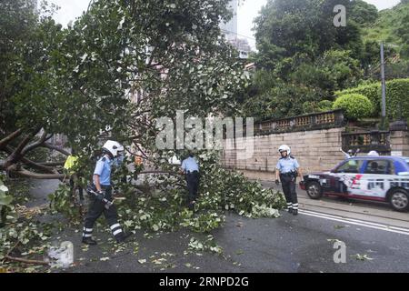 (170823) -- HONGKONG, 23. August 2017 -- Polizisten räumen Baumzweige auf einer Straße in Hongkong, Südchina, 23. August 2017. Hato, der 13. Taifun, der China in diesem Jahr getroffen hat, landete am Mittwoch Mittag in der Stadt Zhuhai in der südchinesischen Provinz Guangdong. Beeinflusst durch die äußere Regenbande von Hato, beeinflusste starker Wind und Regen Hongkong und eine tropische Zyklonwarnung wurde vom Hong Kong Observatory ausgegeben. (wyl) CHINA-HONG KONG-TYPHOON HATO (CN) LiuxYun PUBLICATIONxNOTxINxCHN Hong KONG 23. August 2017 Polizisten Clear Tree Zweige AUF einer Straße in Hong Kong Südchina 23. August 2017 Hato der 13. August Stockfoto