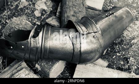 Der Arm einer Ritterrüstung auf Holzstücken. Stockfoto