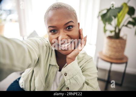 Zuhause, Porträt oder schwarze Frau, die ein Selfie mit einem glücklichen Lächeln auf dem Sofa nimmt, um es in sozialen Medien zu posten. Wohnung, Gesicht oder afrikanische Person, die ein Foto macht Stockfoto