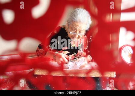 (170831) -- YANTAI, 31. Aug. 2017 -- Lin Guimao, 103, fertigt zu Hause in Yantai City, ostchinesische Provinz Shandong, 30. Aug. 2017. LIN lernte schon als Kind die Papercutting-Fähigkeiten und genießt heute noch das Hobby. ) (Ry) CHINA-YANTAI-PAPERCUTTINGS (CN) ShenxJizhong PUBLICATIONxNOTxINxCHN YANTAI Aug 31 2017 Lin 103 macht ZU Hause in Yantai Stadt Ostchina S Shan Dong Provinz Aug 30 2017 Stockfoto