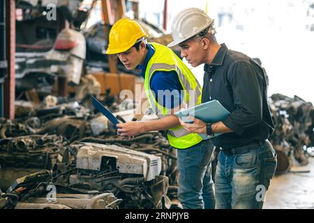 Das leitende Ingenieurteam prüft die alte Ersatzteilliste für den Autoporepartikelmotor für den Verkauf und Recycling in Reparaturwerkstätten Stockfoto