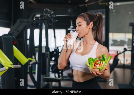 Sport gesunde Frau, die Milch und Gemüse trinkt Gute Quelle von Molkenprotein und Vitamin für die Muskelgesundheit Stockfoto