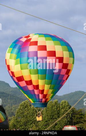 Heißluftballon fesselte Fahrer mit Bergen im Hintergrund Stockfoto