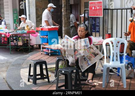 Chinesin liest Zeitung in der Tan Hiok Nee Heritage Street in Johor Bahru, Malaysia Stockfoto