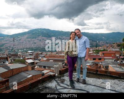 Medellín, Kolumbien - Mai 28 2023: Eine kolumbianische Frau posiert mit einem deutschen Mann mit der Stadt im Hintergrund Stockfoto