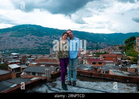 Medellín, Kolumbien - Mai 28 2023: Eine kolumbianische Frau posiert mit einem deutschen Mann mit der Stadt im Hintergrund Stockfoto