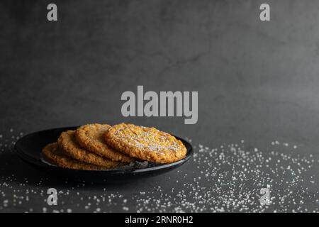 Haferkekse auf schwarzem Teller. Dunkelgrauer Hintergrund. Cafe-Menü. Stockfoto