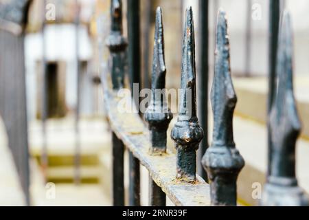 Detail des dekorativen Tores an der Außenseite eines Hauses in Edinburgh. Selektive Fokussierung auf eines der schmiedeeisernen Speerstücke. Horizontale Aufnahme Stockfoto