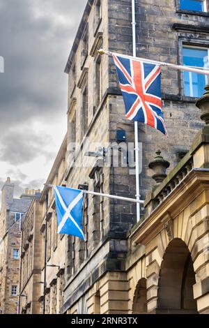 Britische Flagge und schottische Flagge auf einem Gebäude an der Royal Mile in Edinburghs Altstadt. Vertikale Aufnahme. Stockfoto