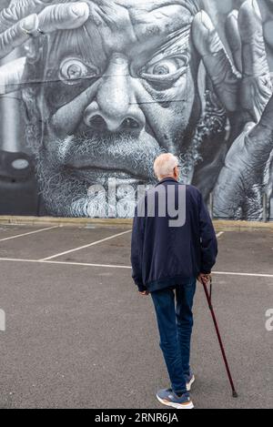 Ältere Männer sehen große Kunstwerke von JEKS im Rahmen der Southend City Jam Street Art Event 2023. Sprühfarbe im Gebäude Stockfoto