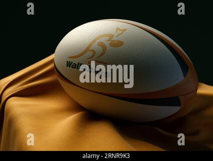 2. September 2023 - Bristol, Großbritannien: Ein 3D-Bild eines Rugby-Balls mit dem australischen Rugby-Logo auf einem drapierten gelben Stoff Stockfoto