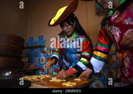 (171002) -- HAIDONG, 2. Okt. 2017 -- Suo Zhanxiang (L) macht Teigblumen, um einen großen Mondkuchen im Suobutan Village des autonomen Bezirks Huzhu Tu in Haidong, Provinz Qinghai im Nordwesten Chinas, 2. Okt. 2017 zu schmücken. Der spezielle Mondkuchen ist ein traditionelles Essen der Tu-Ethnie anlässlich des Mid-Autumn Festivals, das am 4. Oktober dieses Jahres stattfindet. ) (Ry) CHINA-MID-HERBSTFESTIVAL-VORBEREITUNGEN (CN) ZhangxHongxiang PUBLICATIONxNOTxINxCHN Stockfoto