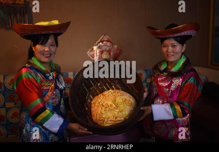 (171002) -- HAIDONG, 2. Oktober 2017 -- Suo Zhanxiang (L) und Suo Zhanhua zeigen einen selbstgemachten Mondkuchen im Suobutan Village of Huzhu Tu Autonomous County in Haidong, nordwestchinesische Provinz Qinghai, 2. Oktober 2017. Der spezielle Mondkuchen ist ein traditionelles Essen der Tu-Ethnie anlässlich des Mid-Autumn Festivals, das am 4. Oktober dieses Jahres stattfindet. ) (Ry) CHINA-MID-HERBSTFESTIVAL-VORBEREITUNGEN (CN) ZhangxHongxiang PUBLICATIONxNOTxINxCHN Stockfoto