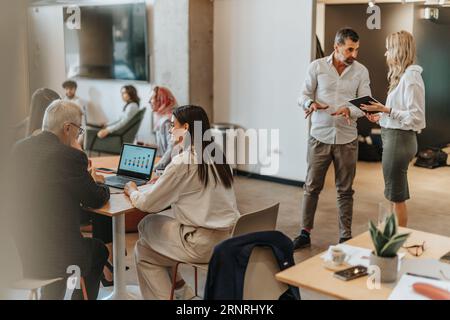 Zwei freiberufliche Mitarbeiter können an einem Tisch sitzen und ihre Projekte besprechen Stockfoto