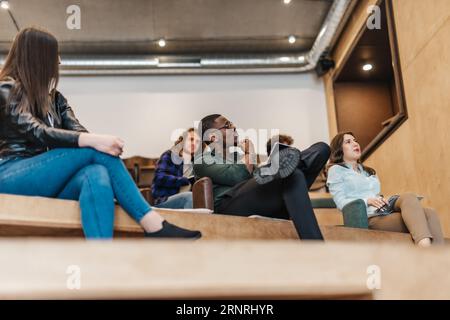 Kreative Kollegen arbeiten Papiere, sitzen drinnen auf der Couch. Arbeit in Marketingagentur oder Designstudio Concept Stockfoto