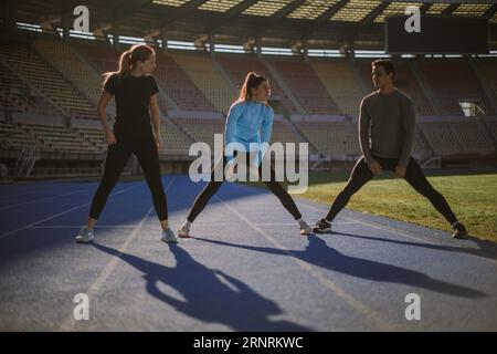 Ein gutaussehender Kerl ist dabei, mit seinen zwei schönen Freundinnen zu trainieren Stockfoto