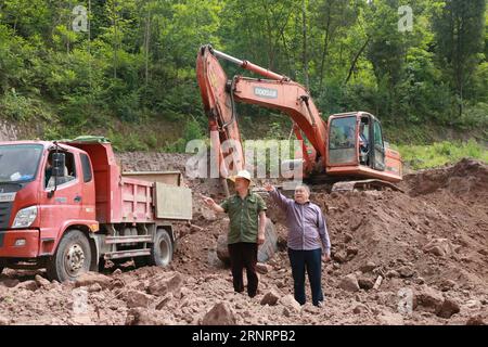 (171012) -- PEKING, 12. Oktober 2017 -- Jiang Yijia (R), Sekretär des Komitees der Kommunistischen Partei Chinas (CPC) des Dorfes Gongshi, gibt Anweisungen auf der Baustelle eines Servicezentrums für Dorfbewohner im Dorf Gongshi im Kreis Pengxi, Provinz Sichuan im Südwesten Chinas, 4. Mai 2017. Jiang, ein Veteran und Unternehmer, kehrte mit 49 Jahren als CPC-Kader in seine Heimatstadt zurück, um den Dorfbewohnern zu helfen, die Armut zu beseitigen. Nun wurde Jiang als Delegierter gewählt, um am 19. Nationalkongress der Partei in Peking vom 18. Oktober teilzunehmen. In etwa einem Jahr wurden insgesamt 2.287 Delegierte elektr Stockfoto