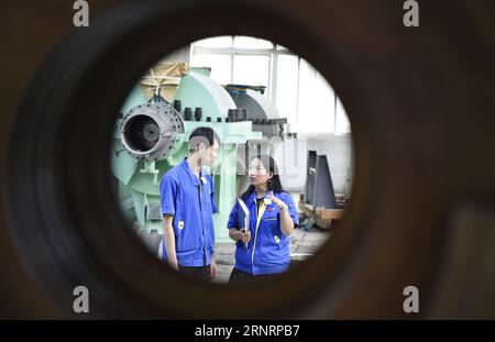 (171012) -- PEKING, 12. Oktober 2017 -- der stellvertretende Chefingenieur Jiang Yan (R) spricht mit ihrem Kollegen in einem Workshop in einem Design-Institut der Shenyang Blower Works Group in Shenyang, Hauptstadt der nordöstlichen Provinz Liaoning, 21. September 2017. Jiang widmete ihre Bemühungen der im Inland entwickelten Technologie des Ethylenkompressors. Sie wurde als Delegierte gewählt, um am 19. Nationalkongress der Kommunistischen Partei Chinas (KPCh) in Peking vom 18. Oktober teilzunehmen. In etwa einem Jahr wurden insgesamt 2.287 Delegierte für die Teilnahme am fünfjährlichen nationalen Kongress gewählt. Laut Anforderung Stockfoto