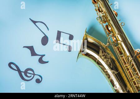 Goldene Saxophone mit Noten auf blauem Hintergrund Stockfoto