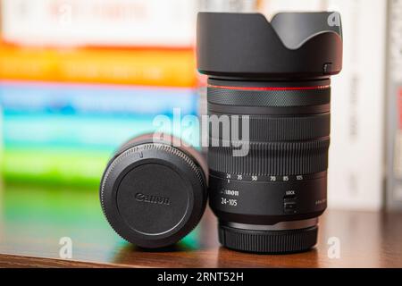 Wroclaw, Polen - 17. Mai 2023: Zoomobjektiv für Canon Kameras RF 24-105mm f4 steht neben liegendem RF 35mm f/1,8 Makroobjektiv auf Bücherregal mit buntem b Stockfoto