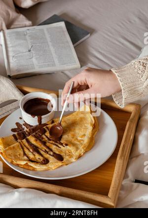 Nahaufnahme von Hand mit Schokoladenpfannkuchen Stockfoto